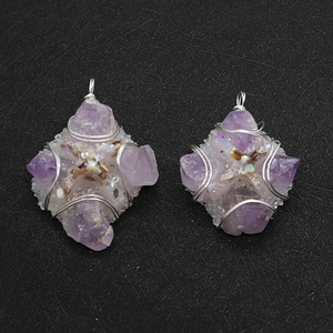 Detail of handmade wire-wrapped amethyst pendant with cross motif and shell accents