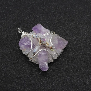 Detailed macro view of raw amethyst crystal pendant with cross wire wrap and top bail
