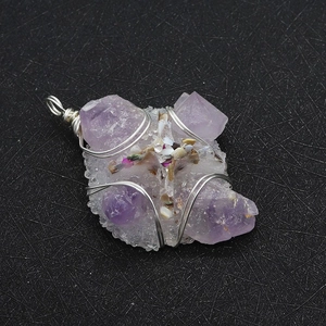 Detailed wire-wrapped amethyst crystal cross pendant with natural purple stones