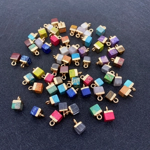 Primer plano de colgantes cúbicos de piedra 5x10mm con aros dorados para joyería DIY