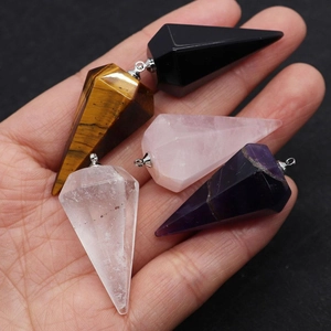 Detailed close-up of natural hexagonal crystal prism pendants held in hand