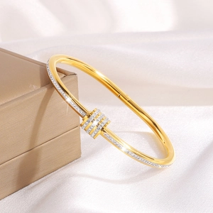 Close-up of gold titanium steel bangle with sparkling crystals on jewelry box