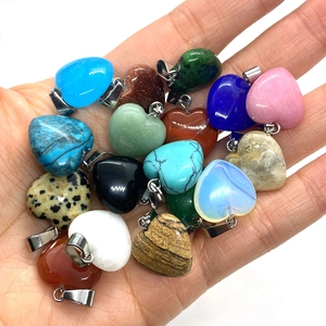 Assorted natural stone heart pendants held in hand for DIY necklace jewelry making