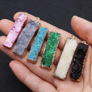Detail von bunten rechteckigen Druzy-Kristallanhängern mit Goldrand für DIY-Schmuck