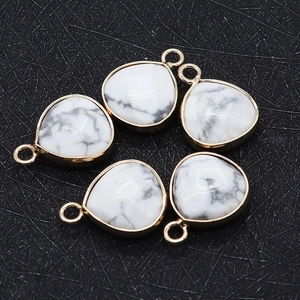 Macro view of five faceted white howlite teardrop charms with gold plated bezels