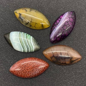 Detailed macro view of five marquise cut dragon vein agate stones in various colors