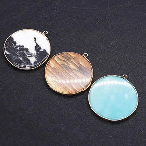 Trois pendentifs circulaires en pierre naturelle avec bordure dorée en bleu et noir