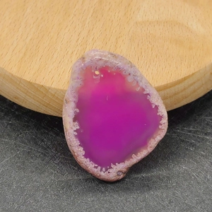 Macro-opname van onregelmatige magenta agaat geode hanger met kristallen en voorgeboord gat