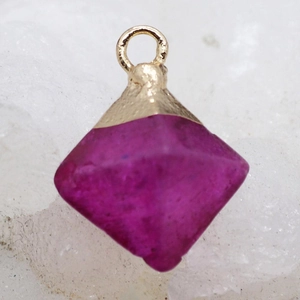 Vue macro d'un pendentif en quartz rose losange avec une bélière en métal doré poli