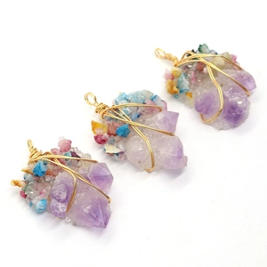 Drei handgefertigte Amethyst-Anhänger mit bunten Steinen und goldener Drahtwicklung auf Weiß