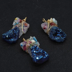 Macro detail of handmade wire-wrapped blue crystal pendants with gold metal wire finish