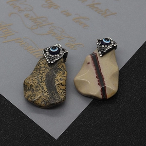 Detailed macro view of natural stone pendants with evil eye inlay and crystals
