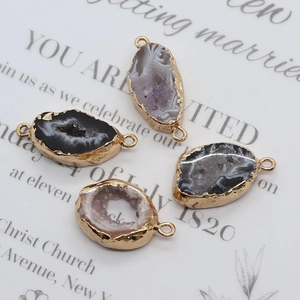Detailed view of irregular agate druzy charms with gold plated edges and double loops