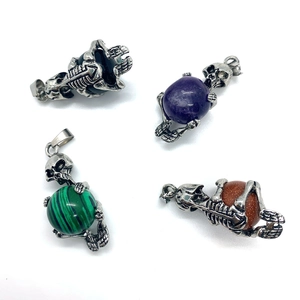 Macro detail of skull-shaped pendants with natural stone spheres and vintage silver finish