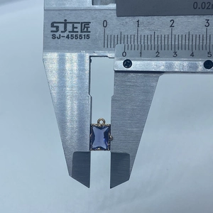 Vue macro mesurant la largeur du pendentif en cristal bleu à 10mm avec un pied à coulisse