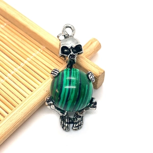 Gothic silver skull pendant with green malachite stone bead on bamboo display base