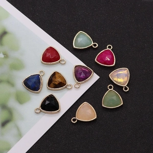 Close-up of nine triangle faceted natural stone pendants with gold plated bezel for DIY