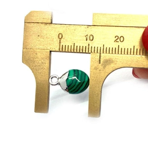 Macro-opname van een 8mm groene aventurijn hanger gemeten met een messing schuifmaat
