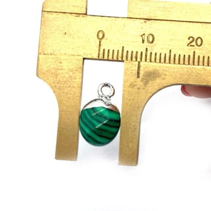 Gefacetteerde malachiet hanger met 8mm diameter meting op een messing schuifmaat