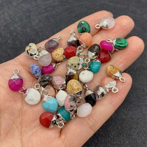 Natuurlijke malachiet en turkoois ovale hangers met zilveren oogjes in de hand