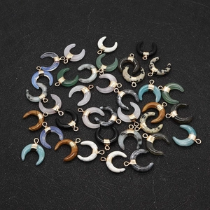 Macro shot of assorted crescent-shaped natural stone pendants with gold metal settings