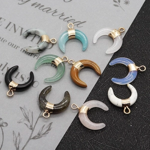 Macro detail of various crescent stone pendants with metal bails for jewelry making
