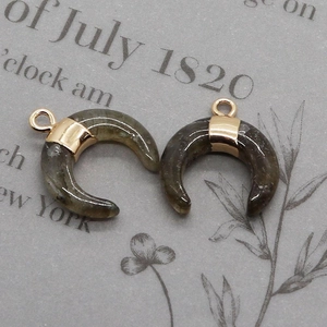 Macro detail of crescent moon pendants in grey labradorite with gold plated loops