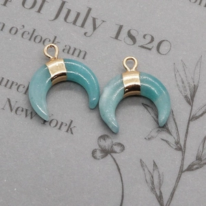 Macro detail of crescent moon natural stone pendants with elegant gold metal bails