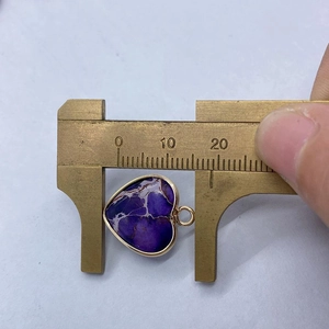 Pendentif coeur en pierre violette avec bordure dorée mesurant 20mm de large au pied à coulisse