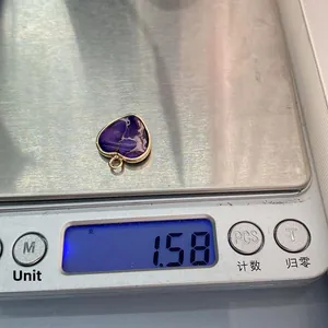 Detailed view of heart-shaped purple emperor stone pendant showing 1.58g weight on scale