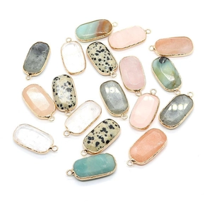 Oval gemstone pendants with gold plated edges in various colors and spotted patterns