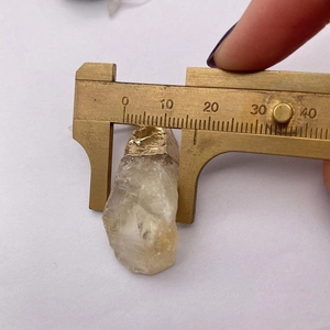 Messung der 15 mm Breite eines natürlichen gelben Kristallanhängers mit einem Messschieber