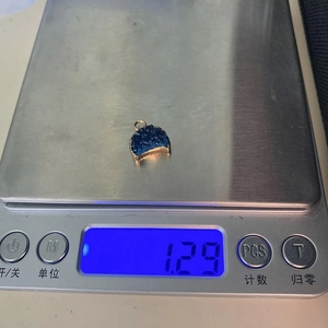 Makrodetail eines Mondsichel-Druzy-Anhängers auf einer Waage mit einem Gewicht von 1,29 g