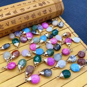 Faceted teardrop natural stone pendants with gold metal rings on a bamboo background
