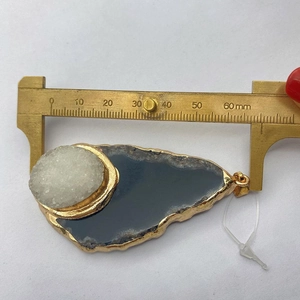 Detailopname van het meten van een agaat druzy hanger met een schuifmaat van 60mm