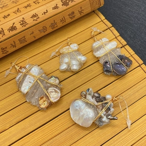 Handmade wire-wrapped natural crystal pendants with baroque pearls on a bamboo mat