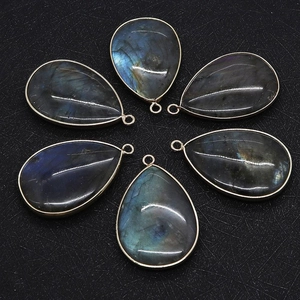Macro view of teardrop labradorite stone pendants with metallic gold plated edging