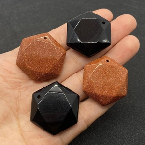 Macro detail of faceted hexagonal pendants in gold sandstone and black onyx stones