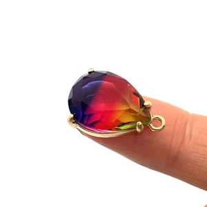 Ciondolo a goccia in pietra naturale arcobaleno sfaccettata con montatura dorata su dito