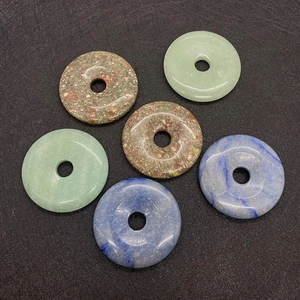 Polished natural aventurine and lapis lazuli donut pendants set on black background