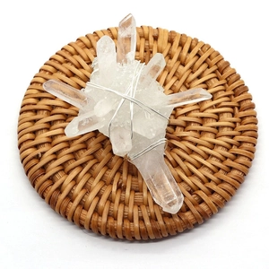 Irregular clear quartz crystal pendant with handmade silver wire wrap on woven mat