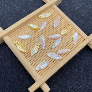 Close-up of polished rhombus sea shell pendants with natural iridescent luster for DIY jewelry