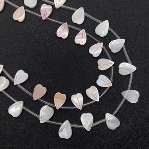 Macro detallada de cuentas de concha natural en forma de corazón para joyería DIY