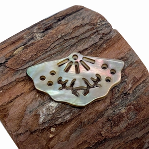 Natural mother of pearl shell fan-shaped pendant with hollow carving on wood texture