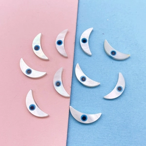 Makroaufnahme von Halbmond-Muschelperlen mit Evil Eye Design für DIY Schmuck