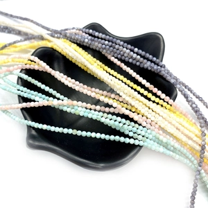 Dettaglio macro di perle di conchiglia colorate da 2mm per gioielli e collane