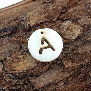 Pendentif en nacre naturelle avec lettre A ajourée sur fond d'écorce rustique