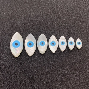 Set mit sieben böse blick muschelperlen in verschiedenen größen auf schwarzem stoff