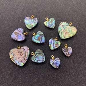 Pendentifs cœur en nacre d'abalone naturelle avec boucles dorées sur fond noir