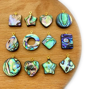 Vue détaillée de pendentifs en nacre d'abalone aux formes variées et anneaux dorés